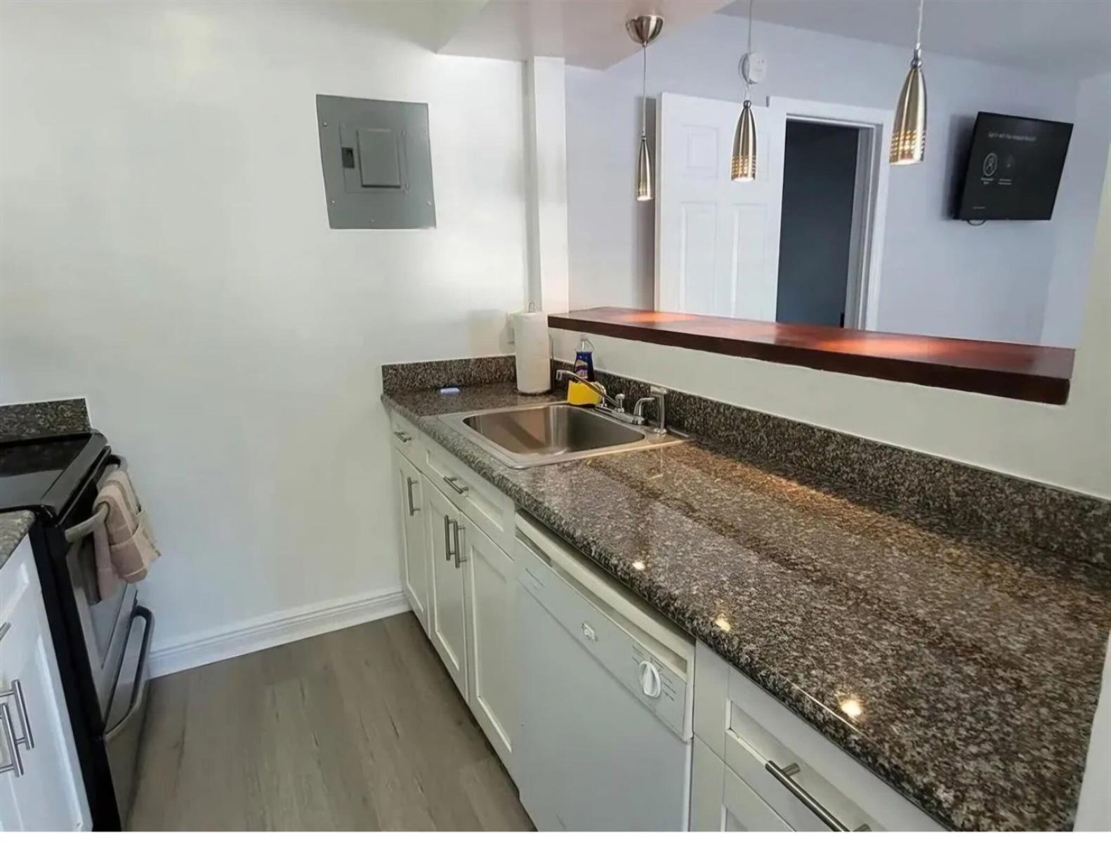 A kitchen features white cabinets, granite countertops, a stainless steel sink, and a breakfast bar — 3226 NE 12th Street # 3, Pompano Beach FL 33062, POMPANO BEACH, FL