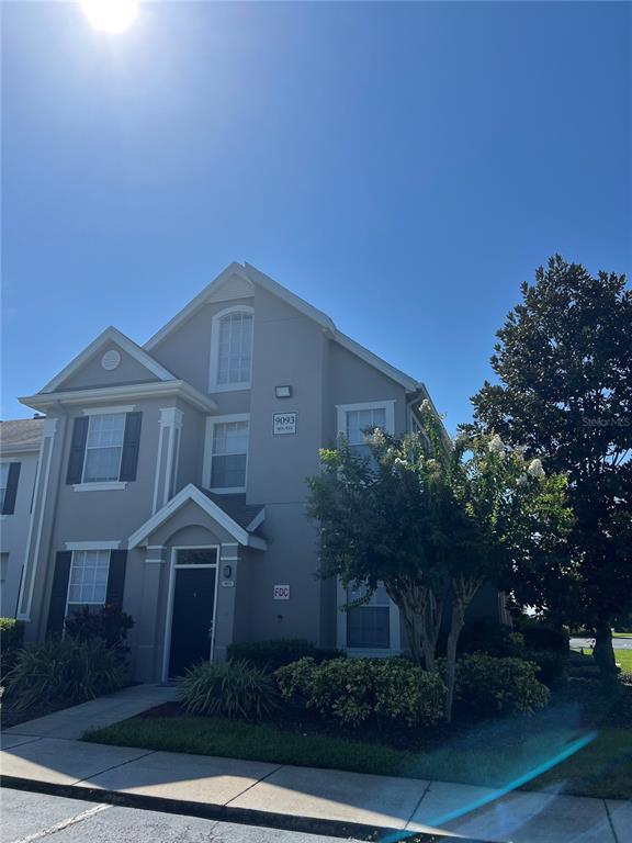 A two-story residential building with gray siding, dark shutters, and a front entrance — 9093 LEE VISTA BOULEVARD UNIT 903, ORLANDO, FL