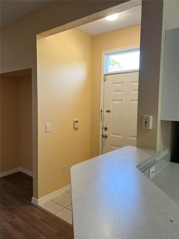 An interior view shows a kitchen counter overlooking an entryway with a front door — 9093 LEE VISTA BOULEVARD UNIT 903, ORLANDO, FL