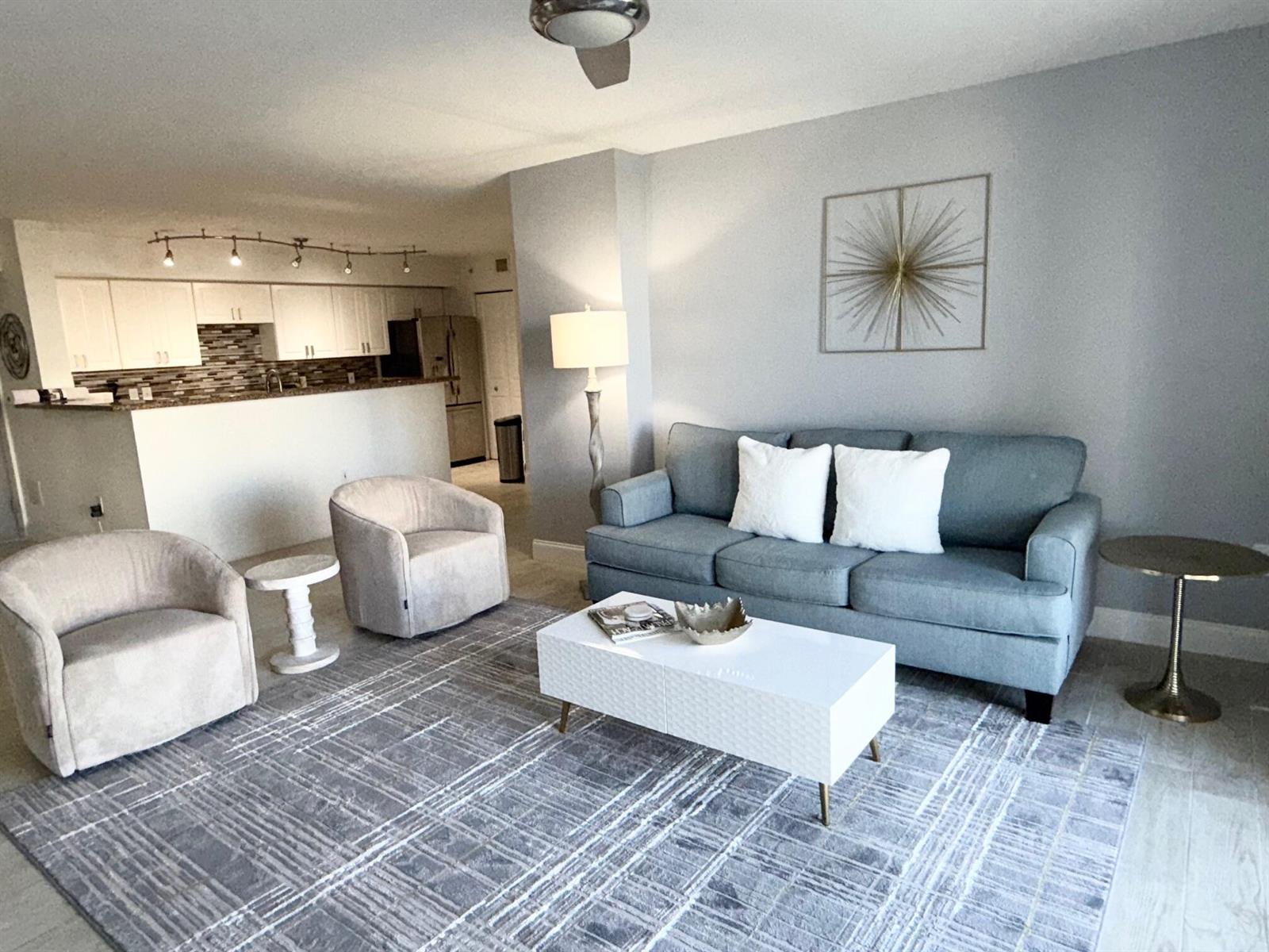 A living room features a blue sofa, two beige armchairs, and a white coffee table — 3594 S Ocean Boulevard # 406, Highland Beach FL 33487, HIGHLAND BEACH, FL