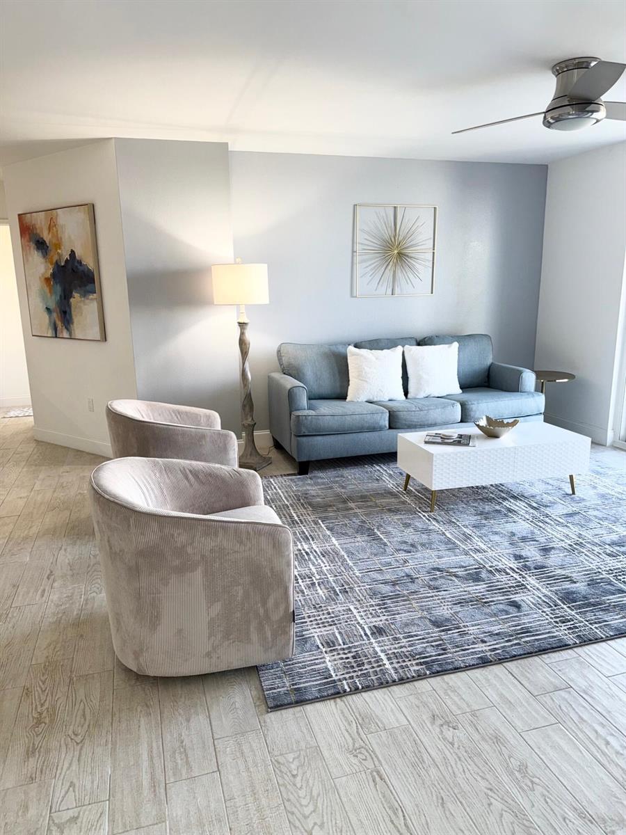 A living room features a blue sofa, two beige chairs, and a white coffee table — 3594 S Ocean Boulevard # 406, Highland Beach FL 33487, HIGHLAND BEACH, FL