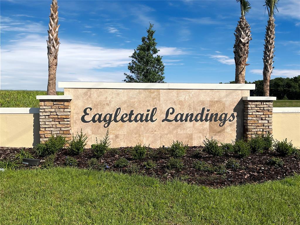 A stone monument sign for Eagletail Landings stands in a grassy area with palm trees — 6888 SPANISH IMPERIAL STREET, HOWEY IN THE HILLS, FL
