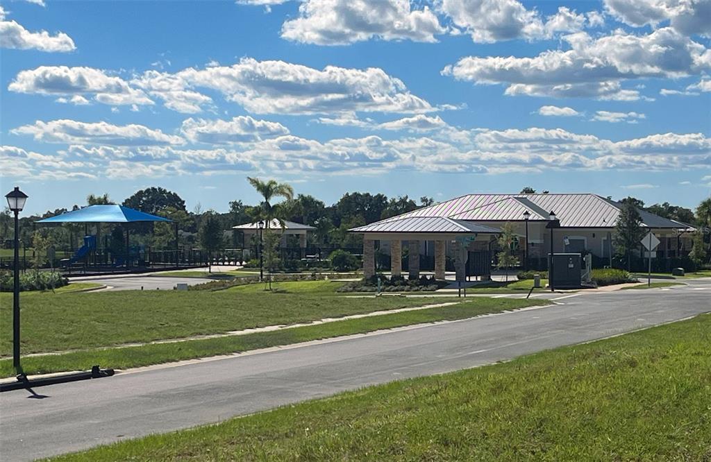 A community clubhouse and playground area with a metal roof and paved parking lot — 6888 SPANISH IMPERIAL STREET, HOWEY IN THE HILLS, FL