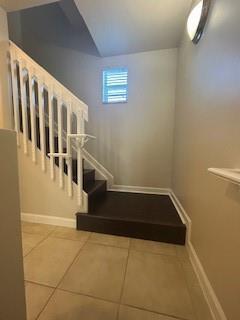 A staircase with white railings and dark wood steps leads up from a tiled foyer — 2337 Vintage Drive, Lighthouse Point FL 33064, LIGHTHOUSE POINT, FL