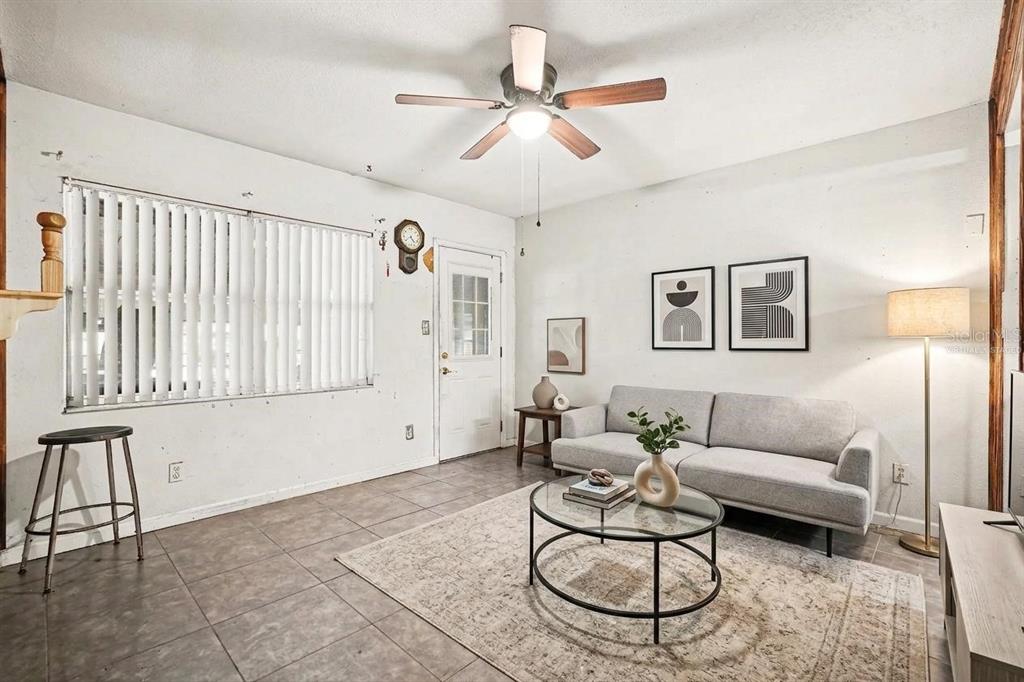 A living room features tile flooring, a ceiling fan, a sofa, and a glass coffee table — 14925 FISHER ROAD, TAMPA, FL