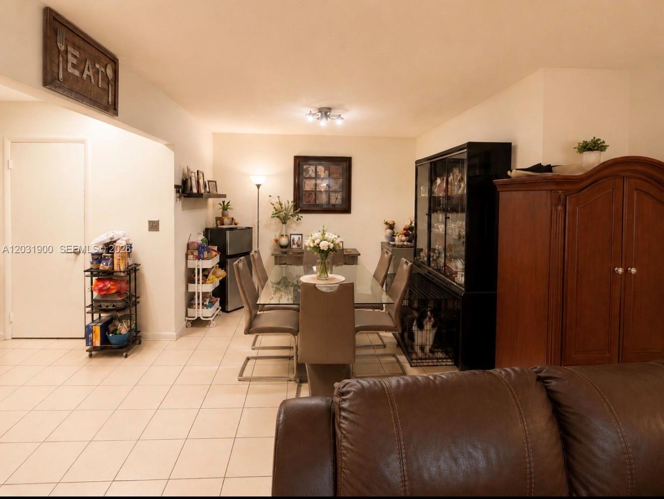 A living room features brown leather sofas, a coffee table, and tile flooring — 12860 SW 43rd Dr # B, Miami FL 33175, MIAMI, FL