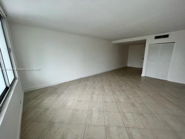 An empty room with light-colored tile flooring, white walls, and a white louvered closet door — 1000 West Ave # 225, Miami Beach FL 33139, MIAMI BEACH, FL