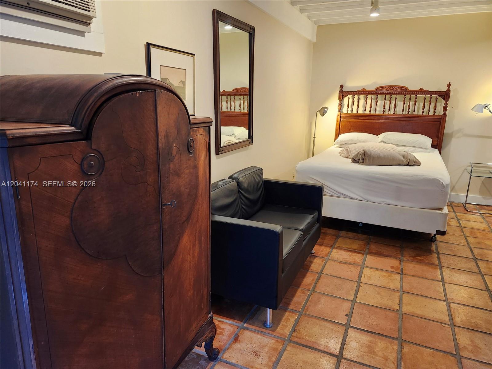 Open French doors reveal an interior room with tile flooring, a desk, and a bed — 3940 Main, Miami FL 33133, MIAMI, FL