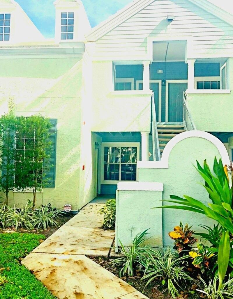 A two-story building with light green stucco walls, a concrete walkway, and exterior stairs — 1020 Crystal Way # C, Delray Beach FL 33444, DELRAY BEACH, FL