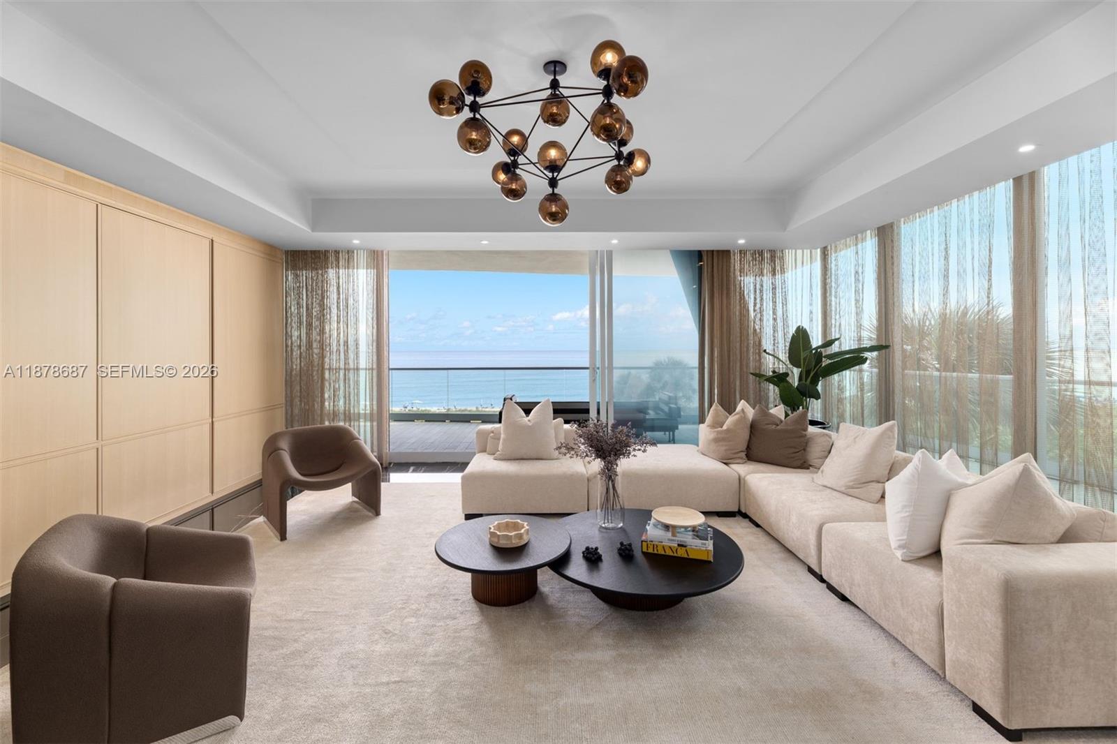 A modern living room features a modular sofa, circular coffee tables, and floor-to-ceiling ocean views — 9349 Collins Ave # 406, Surfside FL 33154, SURFSIDE, FL