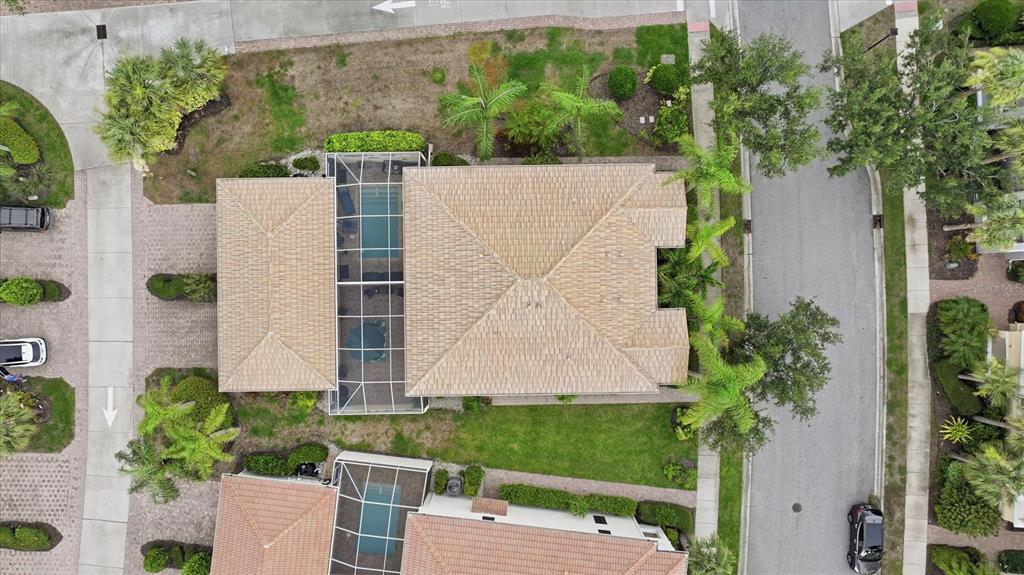 An aerial view shows a house with a tiled roof, a screened pool, and landscaping — 1585 DORGALI DRIVE, SARASOTA, FL
