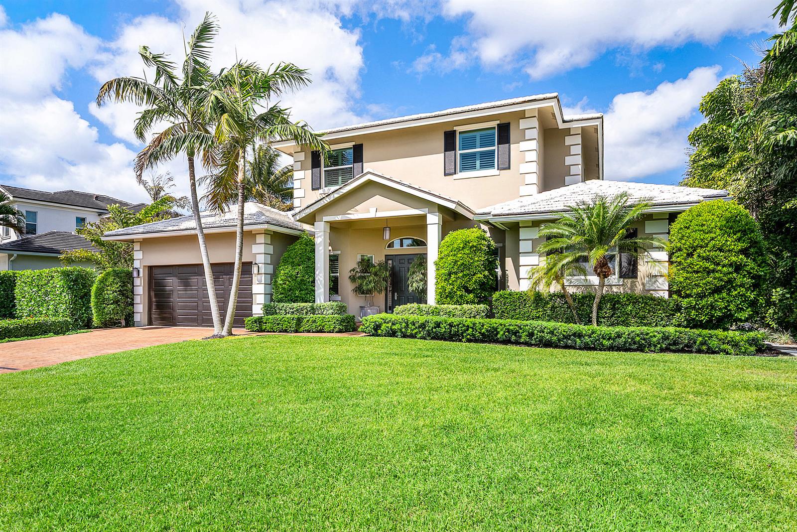 A two-story suburban house with a brown garage, palm trees, and a manicured lawn — 33 Spanish River Drive, Ocean Ridge FL 33435, OCEAN RIDGE, FL