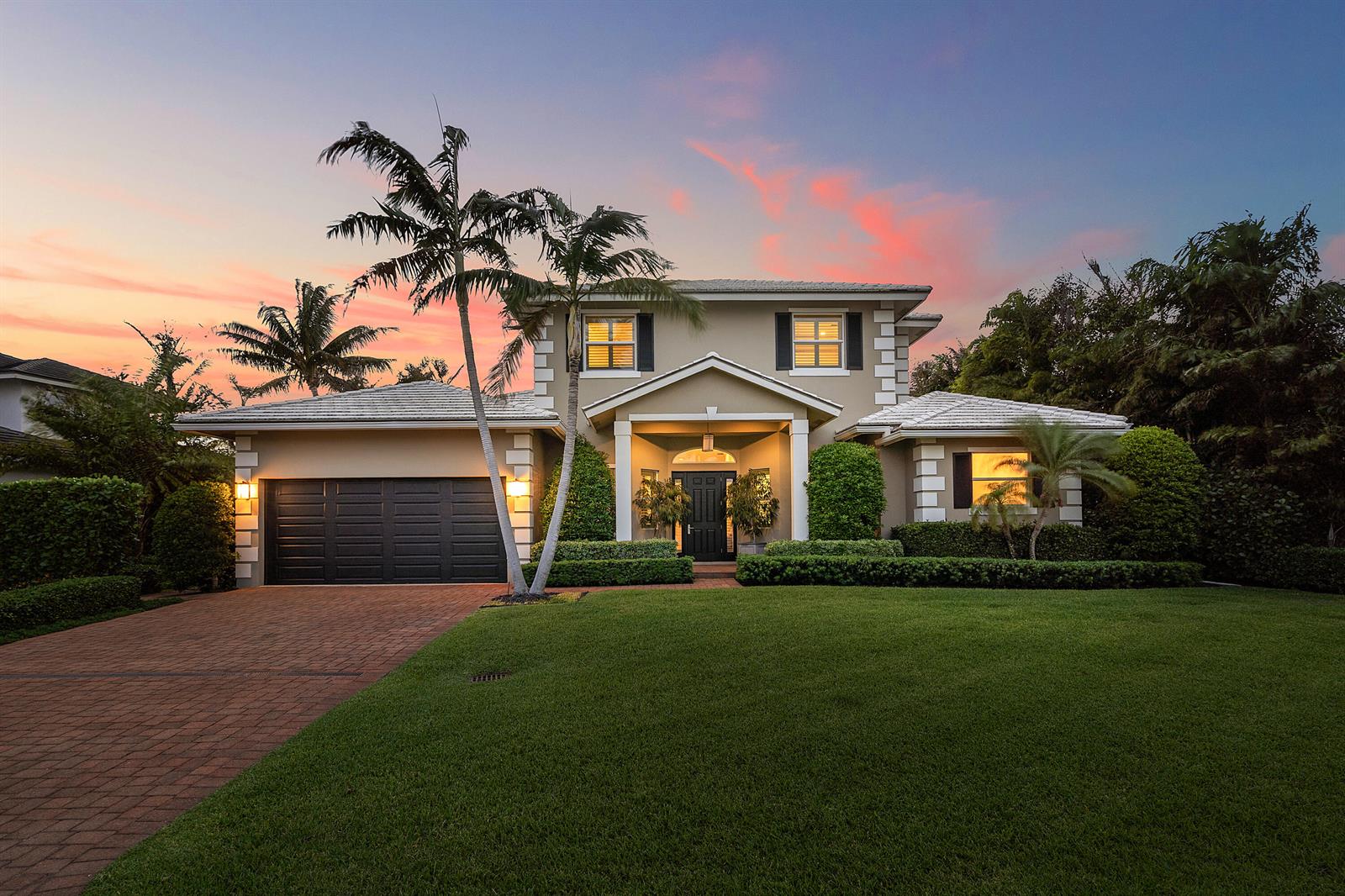 A two-story house with a brick driveway, palm trees, and a sunset sky — 33 Spanish River Drive, Ocean Ridge FL 33435, OCEAN RIDGE, FL