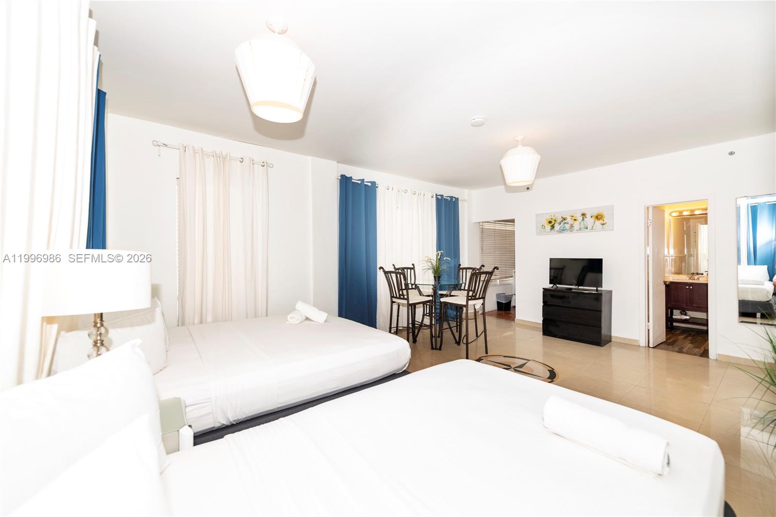 A hotel room features two beds, a small dining table, and an attached bathroom — 918 Ocean Dr # 203, Miami Beach FL 33139, MIAMI BEACH, FL