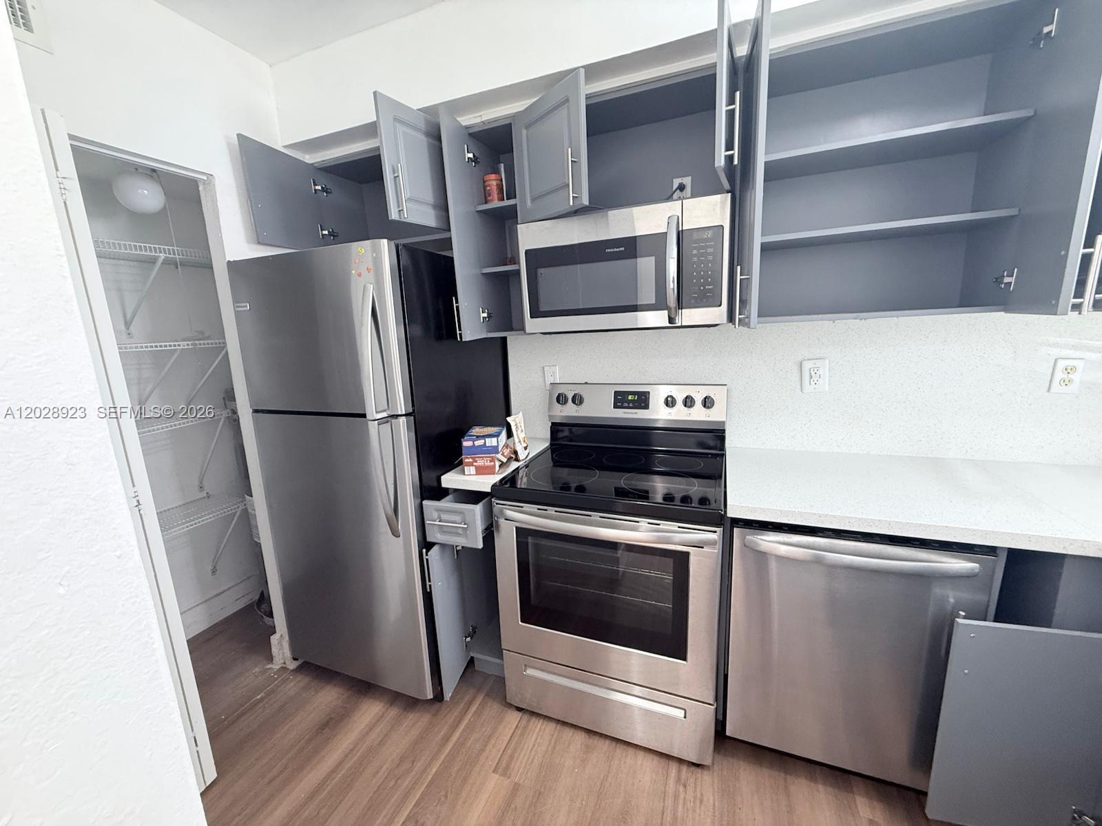 A kitchen features stainless steel appliances, grey cabinets, and a walk-in pantry — 209 NW 84th St # 209, Miami FL 33150, MIAMI, FL