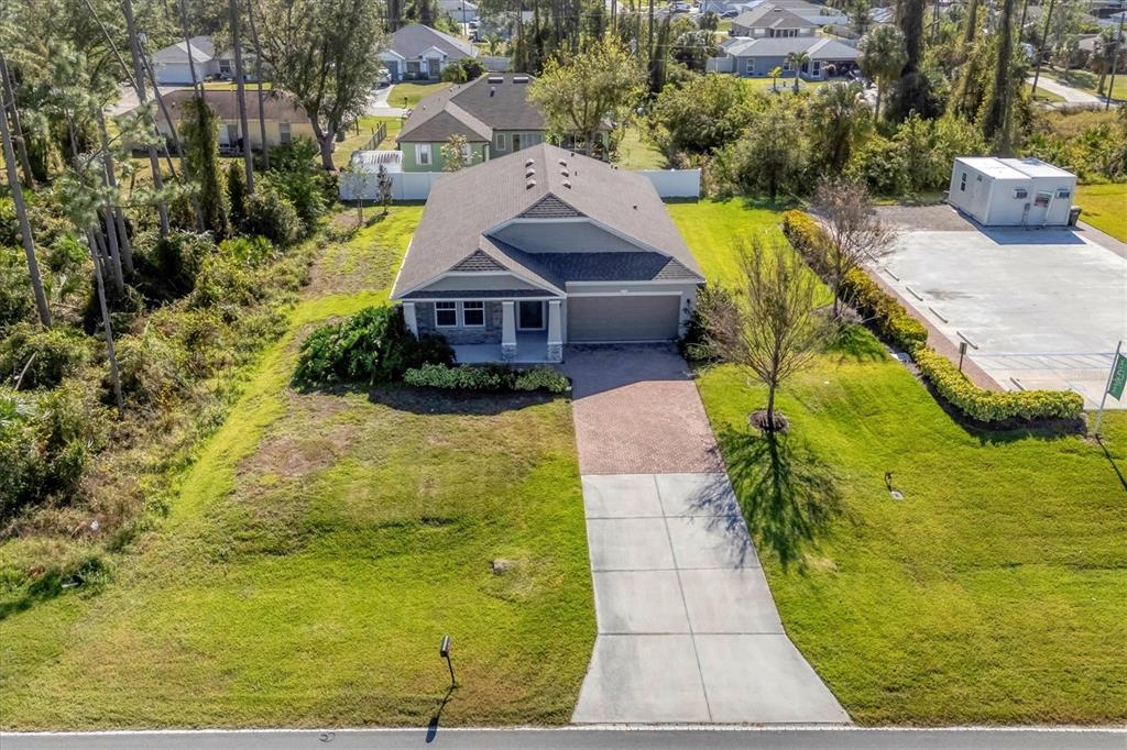 An aerial view shows a single-story house with a paved driveway and a grassy yard — 2179 W PRICE BLVD, NORTH PORT, FL