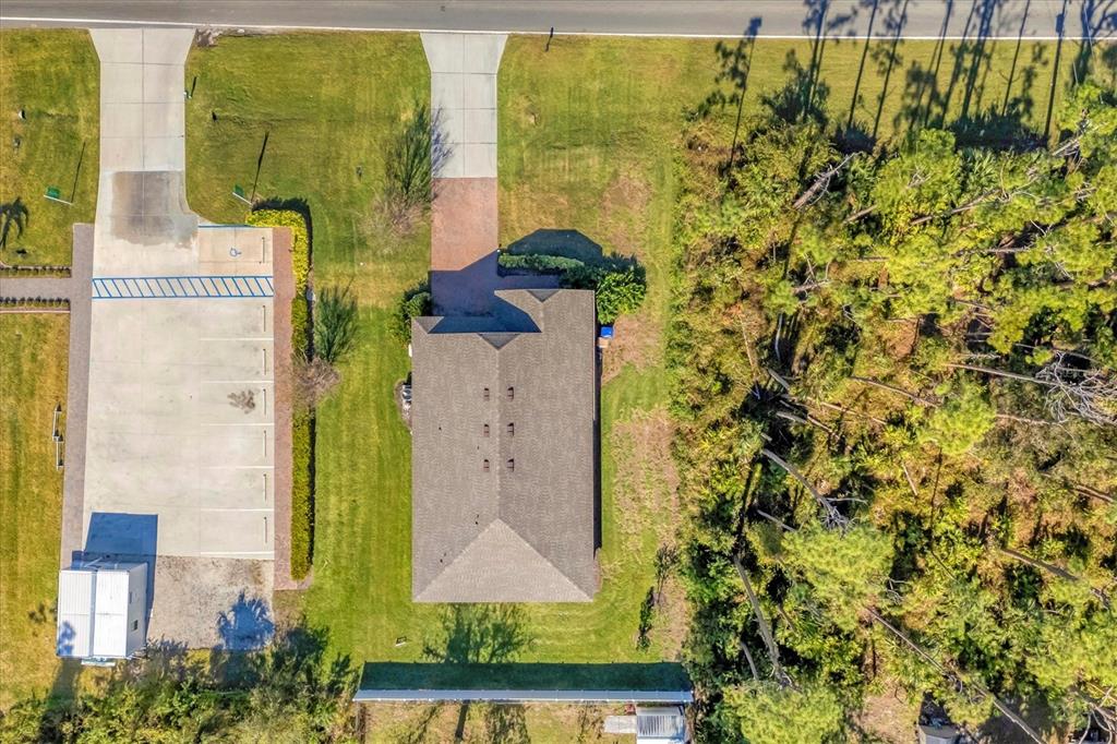 An aerial view shows a house with a gray roof, a driveway, and adjacent parking — 2179 W PRICE BLVD, NORTH PORT, FL