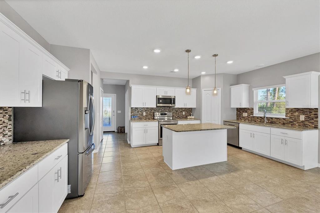 A kitchen features white cabinets, granite countertops, stainless steel appliances, and a central island — 2179 W PRICE BLVD, NORTH PORT, FL