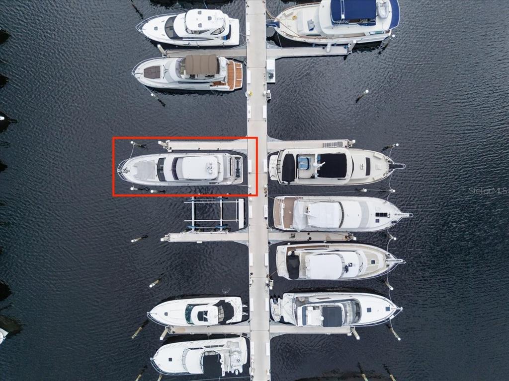 An aerial view shows several boats docked along a central pier in a marina — 102 RIVIERA DUNES WAY UNIT C-22, PALMETTO, FL