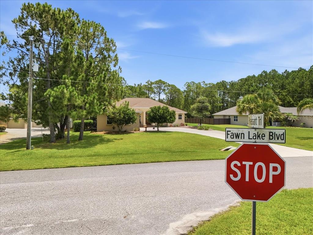 A stop sign stands at the intersection of Fawn Lake Blvd in front of a house — 3095 FAWN LAKE BOULEVARD, MIMS, FL