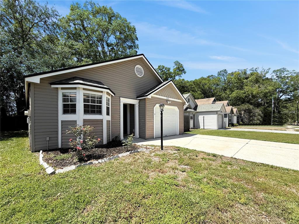 A single-story house with gray siding, a bay window, and a one-car garage — 1854 ALBERTA COURT N, MIDDLEBURG, FL