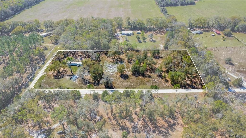 An aerial view shows a rectangular plot of land containing a mobile home and trees — 5590 NW 76TH AVENUE, CHIEFLAND, FL