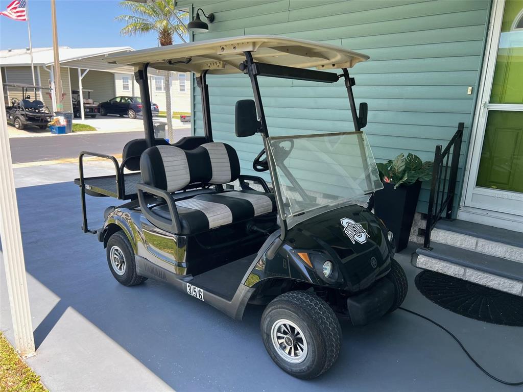 A black Yamaha golf cart with Ohio State branding parked on a concrete driveway — 13225 101ST STREET UNIT 356, LARGO, FL