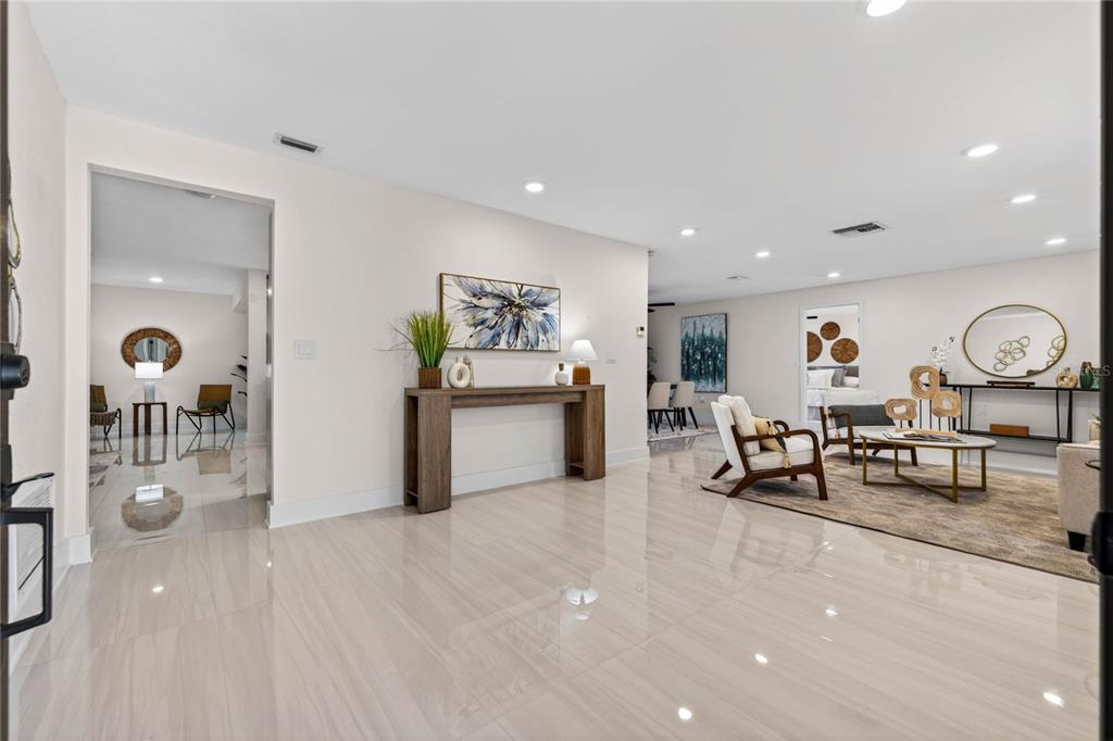 A bright, open-concept living area features light-colored tile flooring, recessed lighting, and modern decor — 4346 MARINE PARKWAY, NEW PORT RICHEY, FL