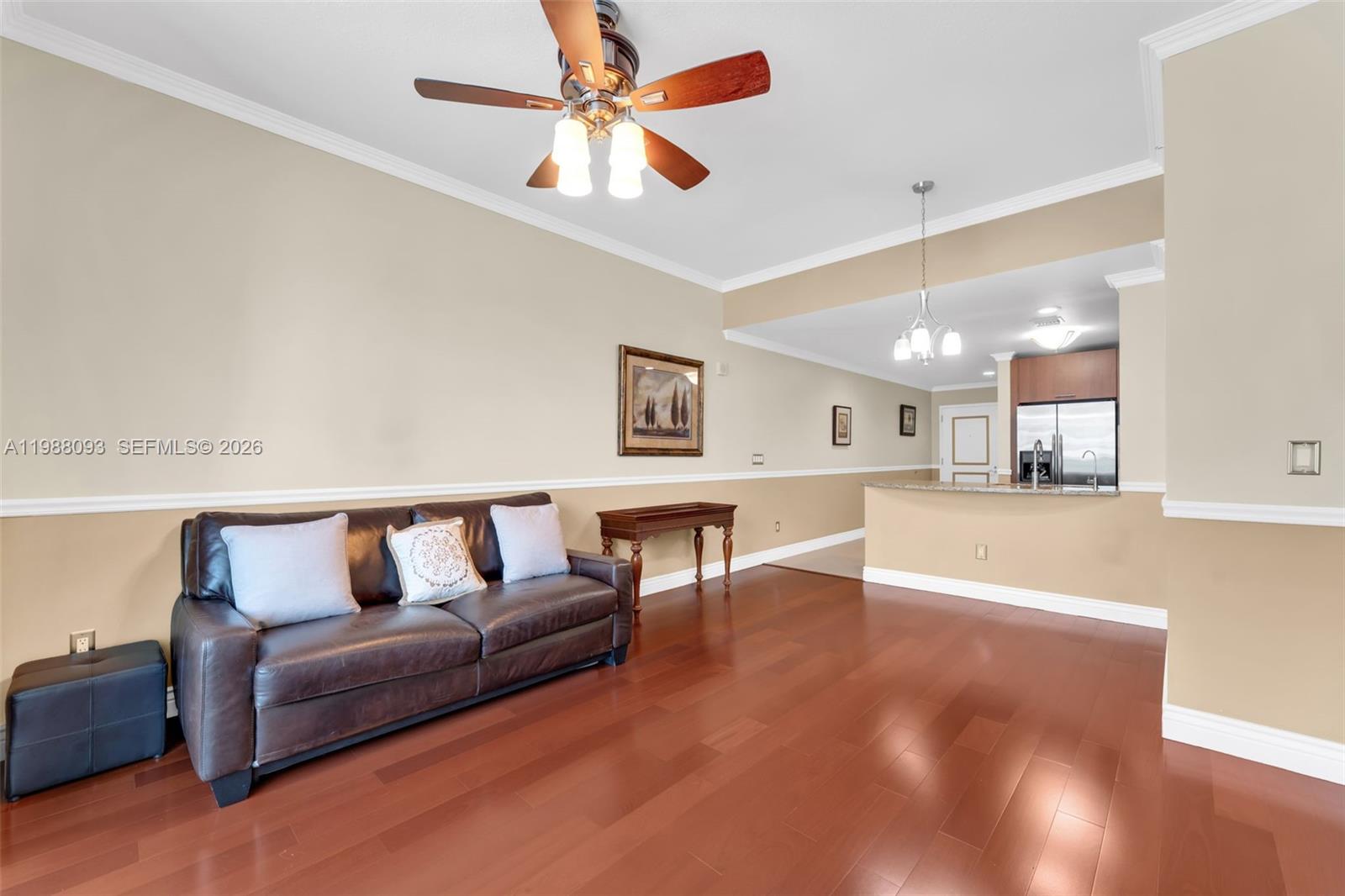 A living room with hardwood floors, a leather sofa, and an open kitchen area — 1945 S Ocean Dr # 604, Hallandale Beach FL 33009, HALLANDALE BEACH, FL