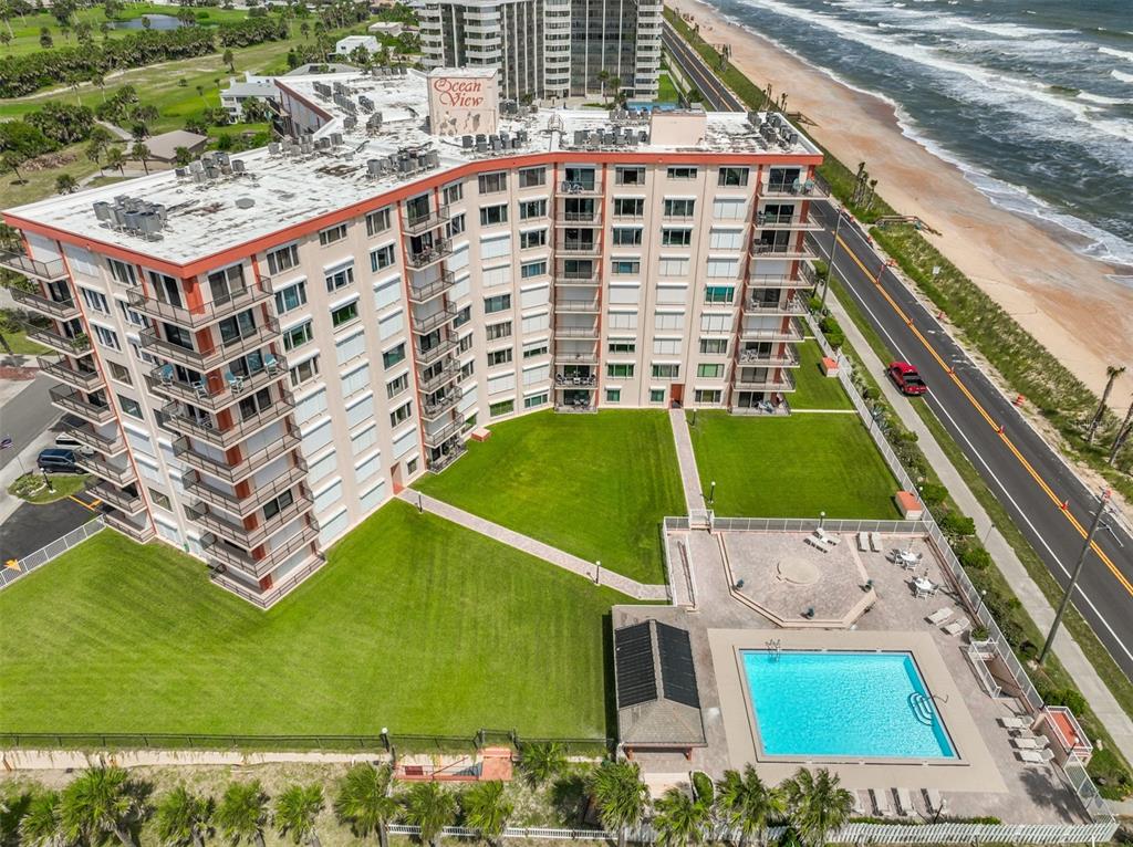 An aerial view of a multi-story apartment building with a pool and oceanfront location — 3600 S OCEAN SHORE BOULEVARD UNIT 115, FLAGLER BEACH, FL