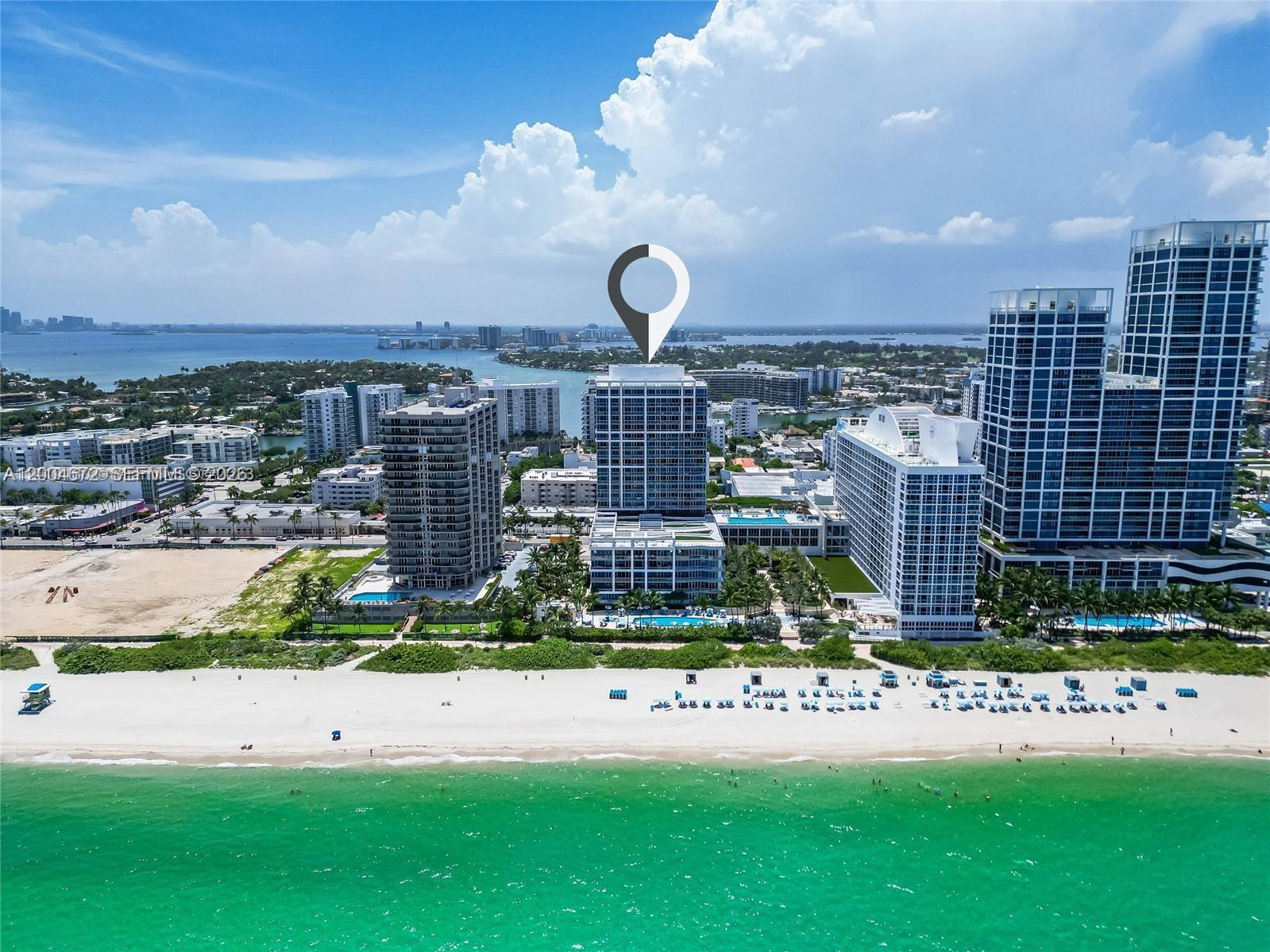 An aerial view shows a high-rise building on a beach with turquoise ocean water — 6799 Collins Ave # 1602, Miami Beach FL 33141, MIAMI BEACH, FL