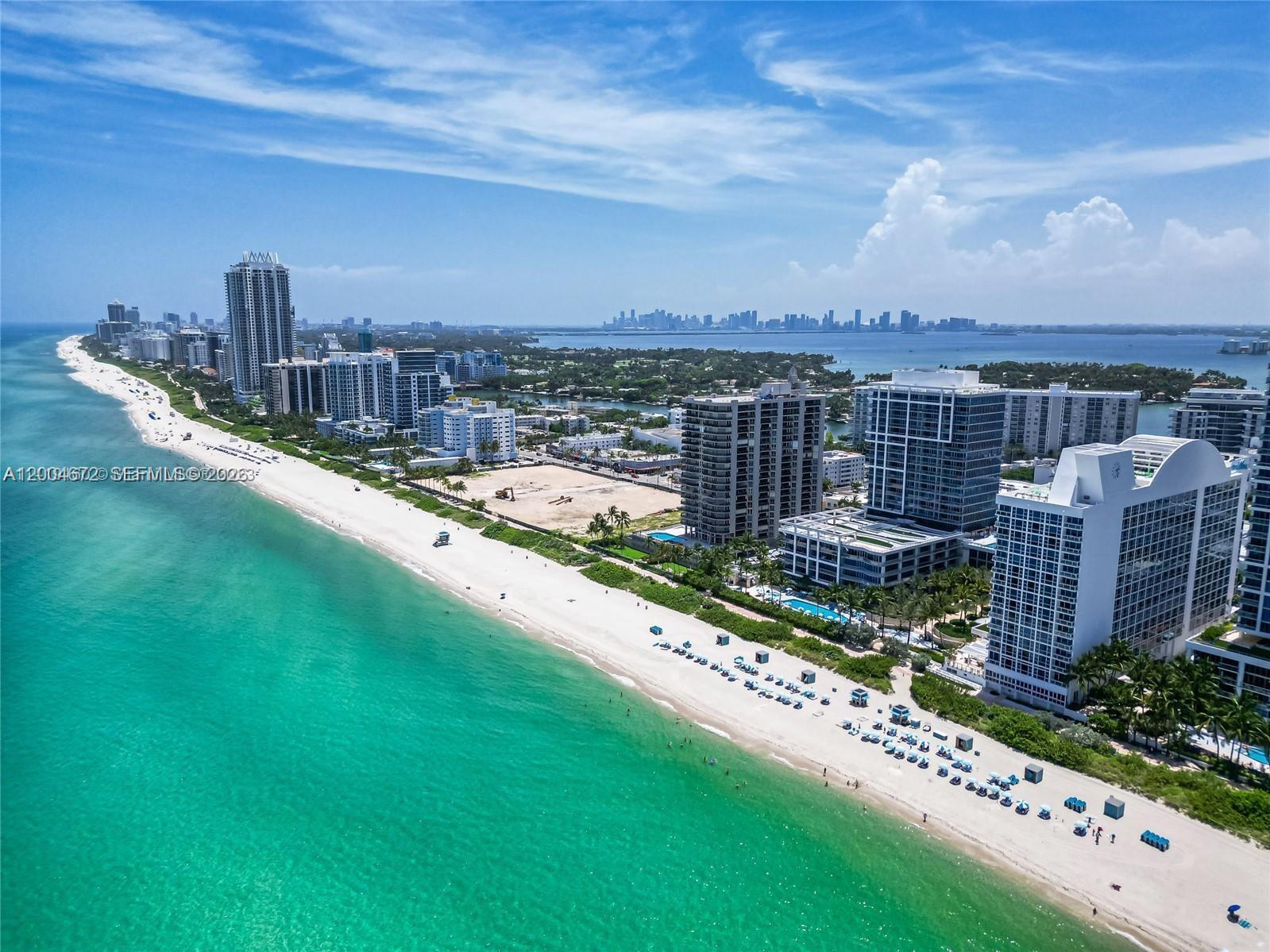 An aerial view shows a sandy beach along a turquoise ocean with high-rise buildings nearby — 6799 Collins Ave # 1602, Miami Beach FL 33141, MIAMI BEACH, FL