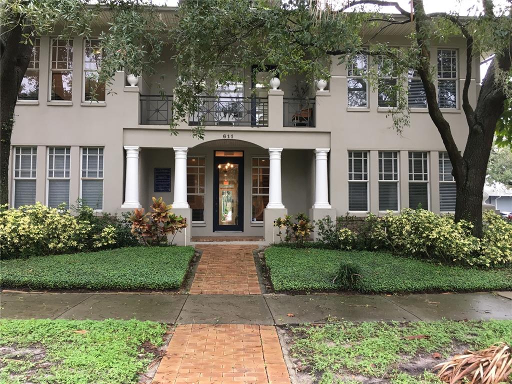 A two-story building with a brick walkway, white columns, and a second-floor balcony — 611 W BAY STREET, TAMPA, FL