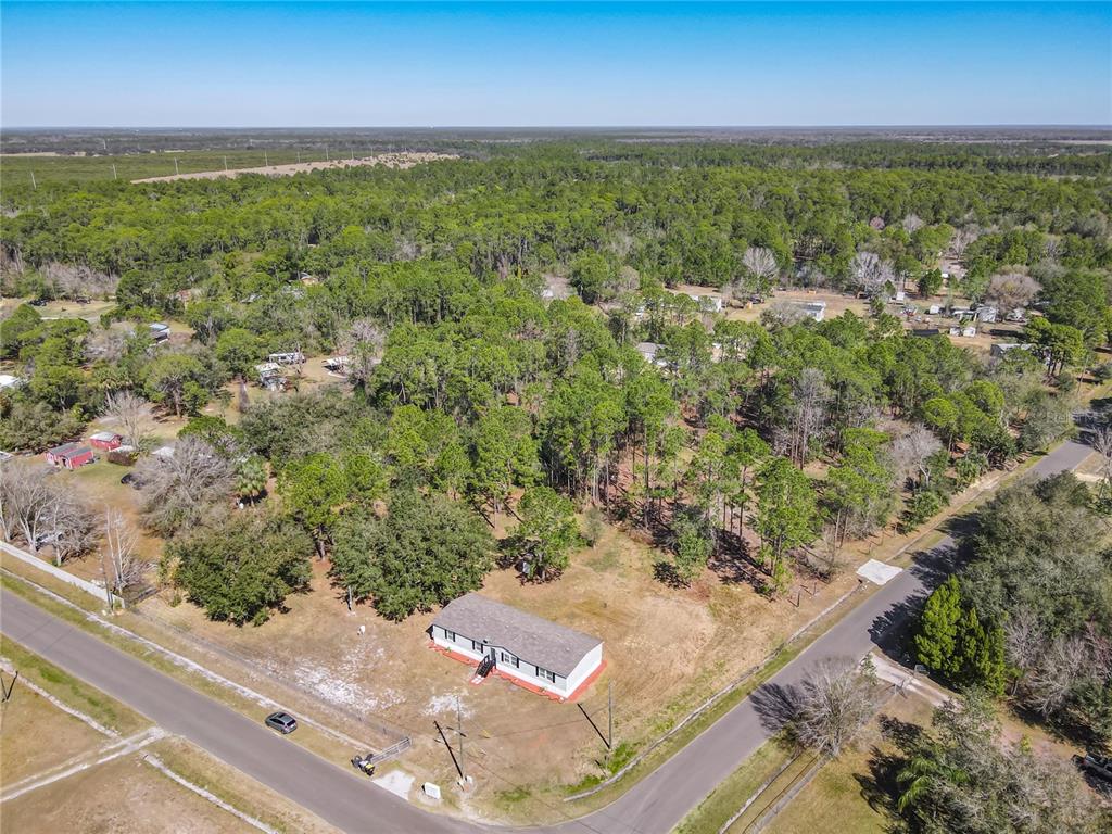 An aerial view shows a single-story house on a large, partially wooded corner lot — 3564 REAGAN BOULEVARD, LAKE WALES, FL