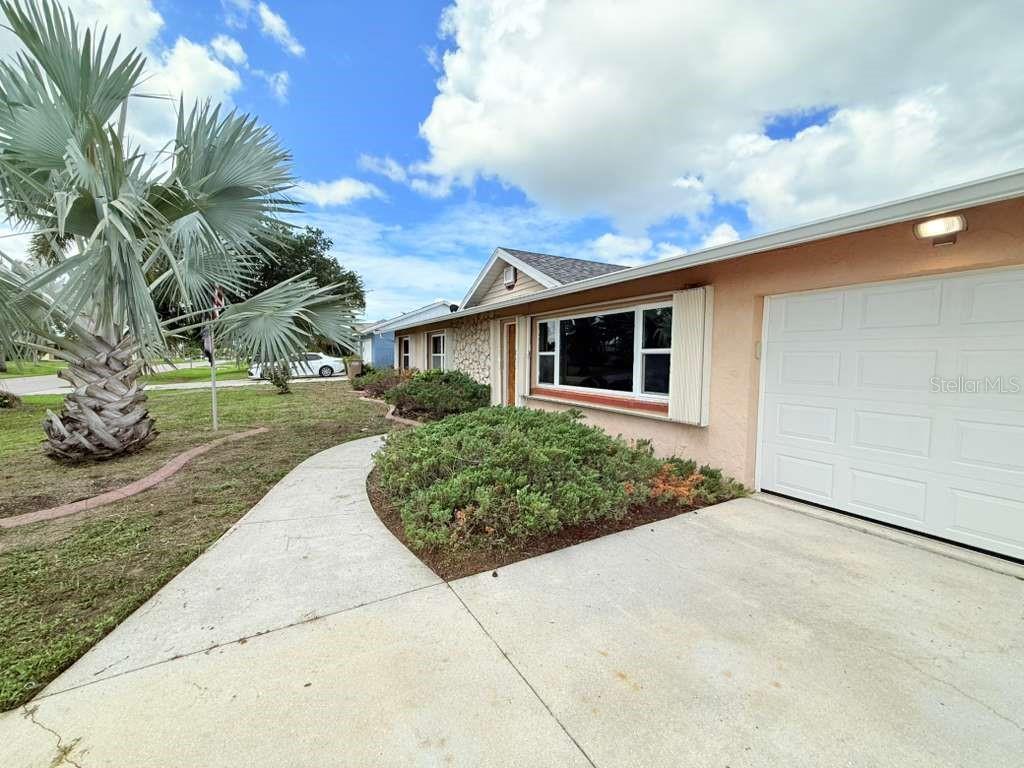 A single-story house exterior features a concrete driveway, a front walkway, and a palm tree — 4418 SW 1ST AVENUE, CAPE CORAL, FL