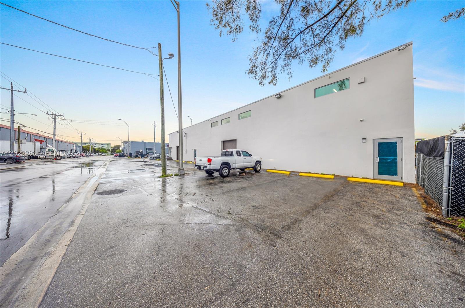 A white industrial building exterior features a parking lot with a white pickup truck — 7550 W 2nd Ct, Hialeah FL 33014, HIALEAH, FL