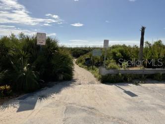 A sandy path leads through coastal vegetation toward a beach access point — 11 SWEET BAY DRIVE, PALM COAST, FL