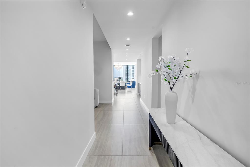 A bright hallway with light tile flooring leads to an open living area with windows — 301 1ST STREET S UNIT 2604, ST PETERSBURG, FL