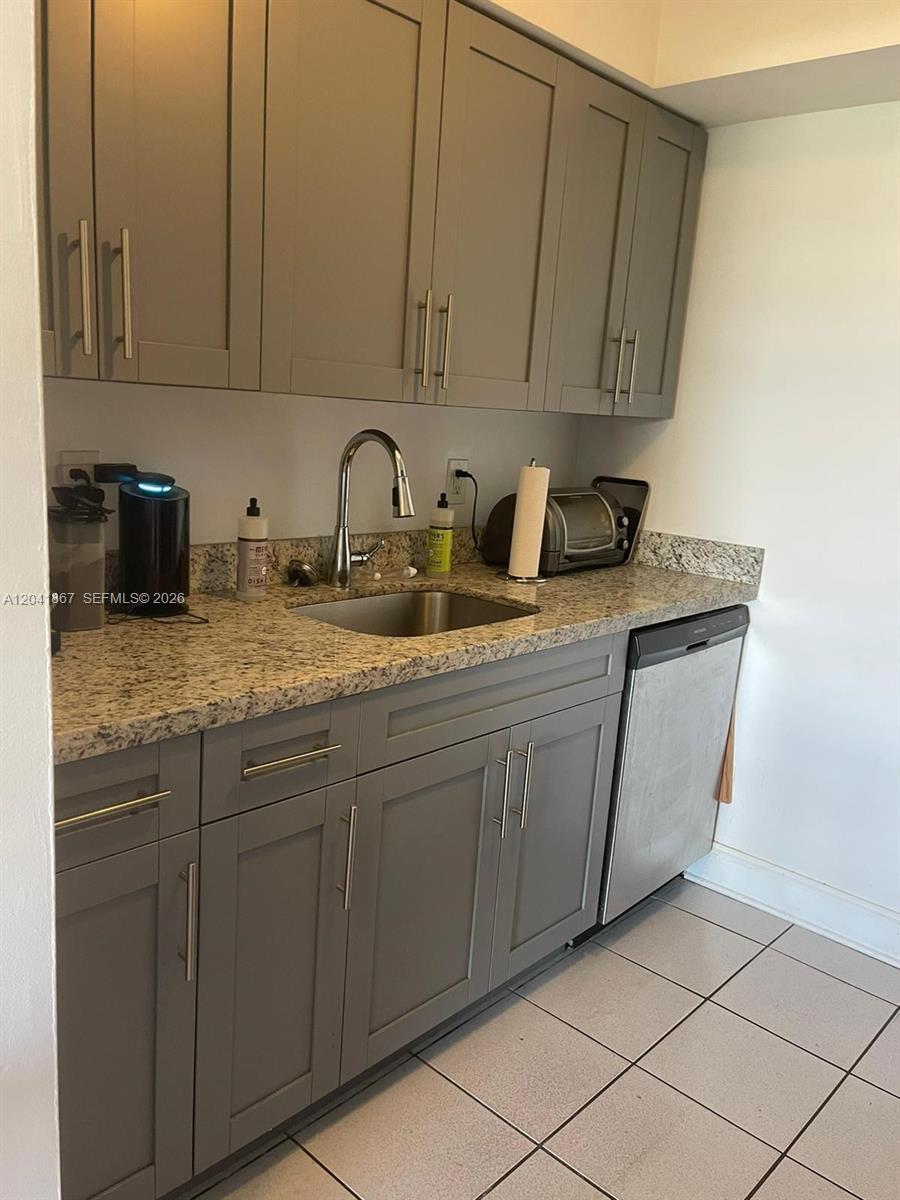 A kitchen features gray shaker cabinets, granite countertops, a stainless steel sink, and appliances — 130 Mendoza Ave # 33, Coral Gables FL 33134, CORAL GABLES, FL