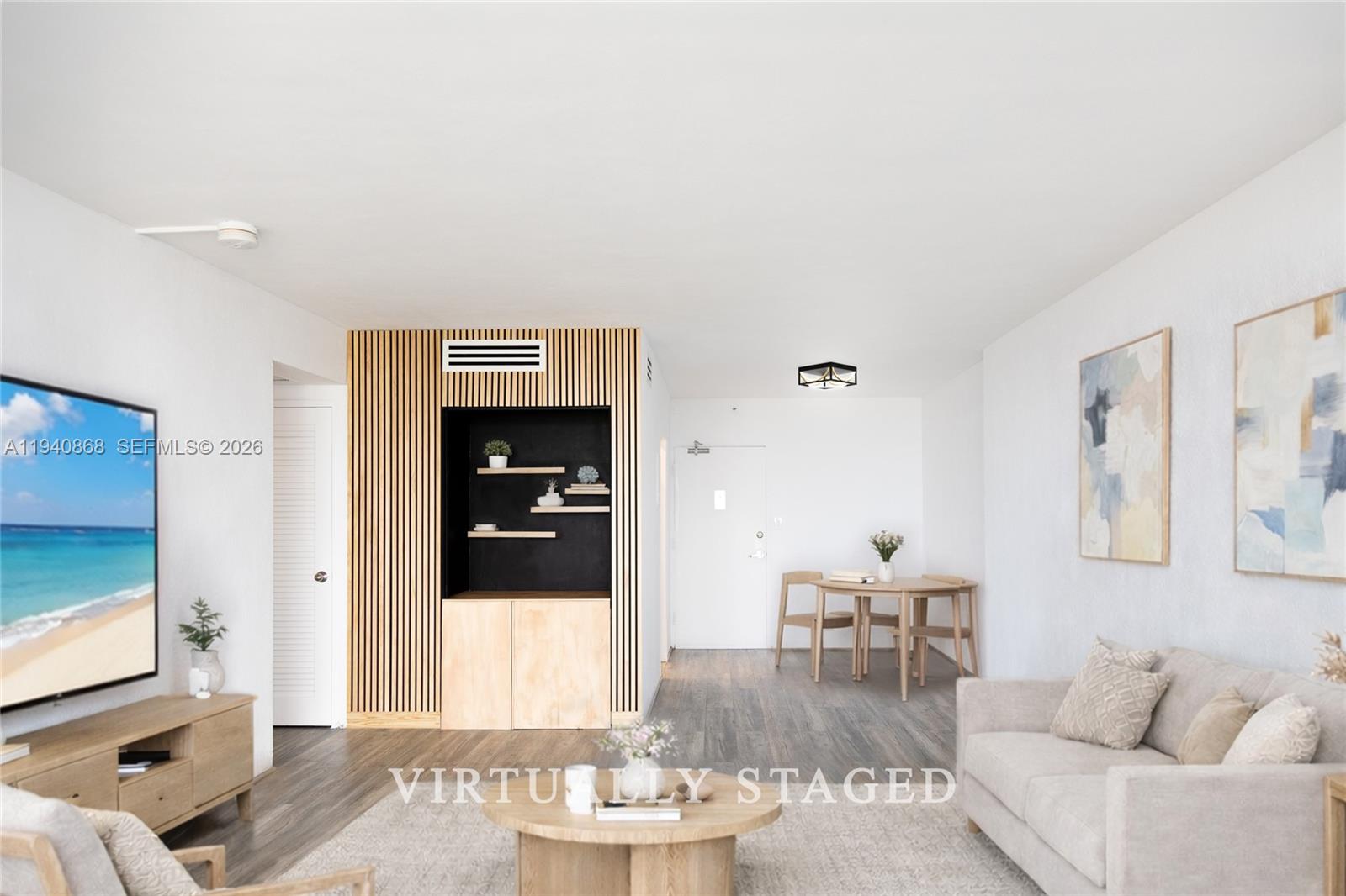 This living room features wood-slat wall paneling, a television, a sofa, and a dining area — 1200 West Ave # 708, Miami Beach FL 33139, MIAMI BEACH, FL