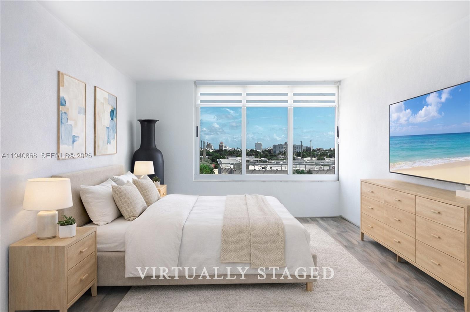 This virtually staged bedroom features a bed, dresser, and a window with a city view — 1200 West Ave # 708, Miami Beach FL 33139, MIAMI BEACH, FL