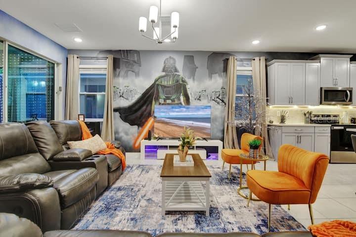 A living room features a Star Wars mural, gray leather seating, and orange accent chairs — 1919 TROPICAL PALMS CIRCLE, KISSIMMEE, FL