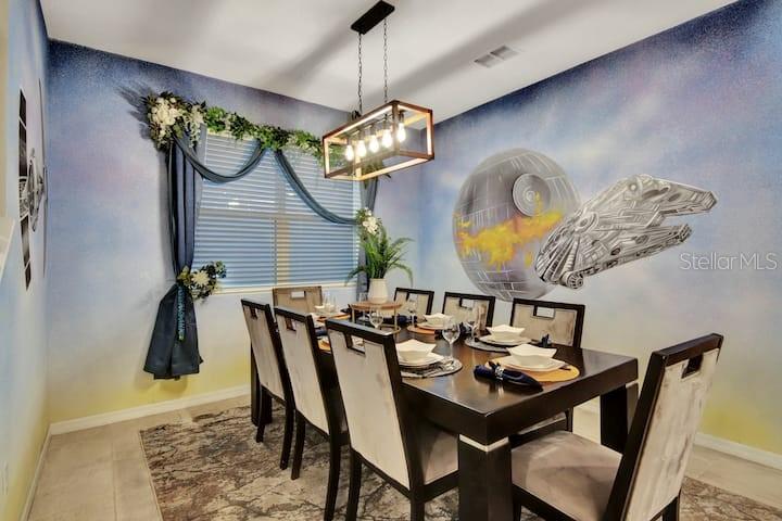 A dining room features a Star Wars-themed mural, a dark wood table, and a rectangular chandelier — 1919 TROPICAL PALMS CIRCLE, KISSIMMEE, FL