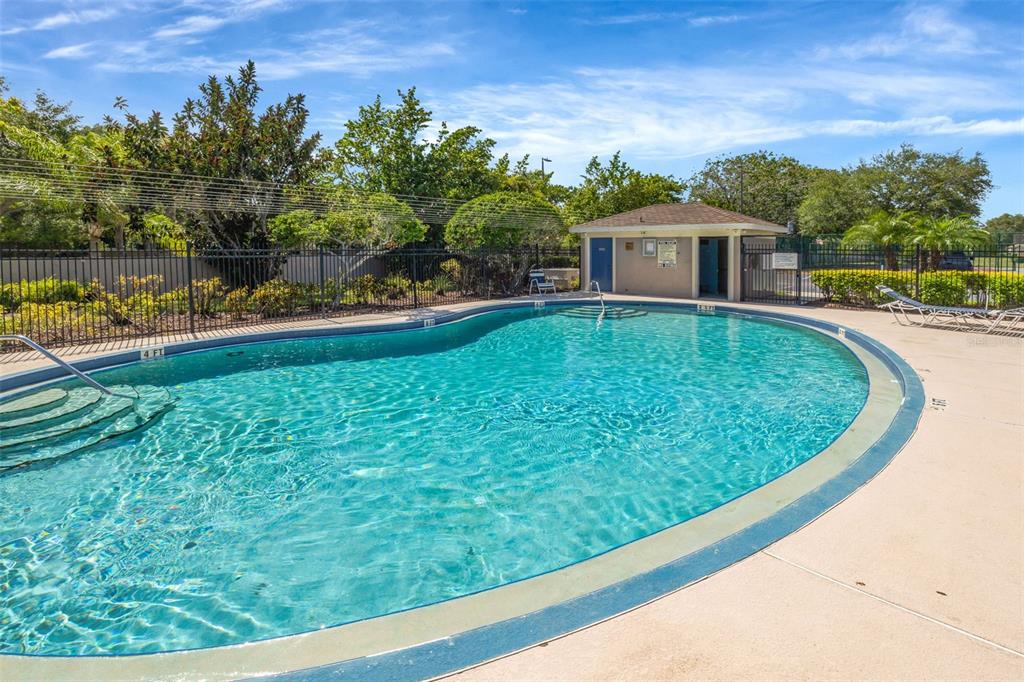 A swimming pool with a surrounding deck and a small utility building in the background — 6127 BAYSIDE KEY DRIVE, TAMPA, FL