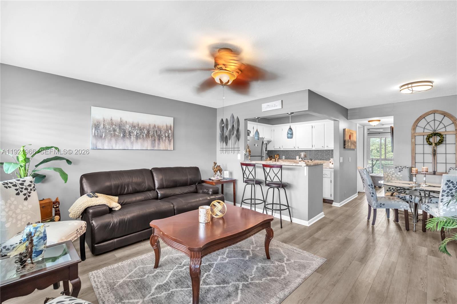 A living room with a brown leather sofa, coffee table, and an adjacent kitchen area — 244 Durham F # 244, Deerfield Beach FL 33442, DEERFIELD BEACH, FL