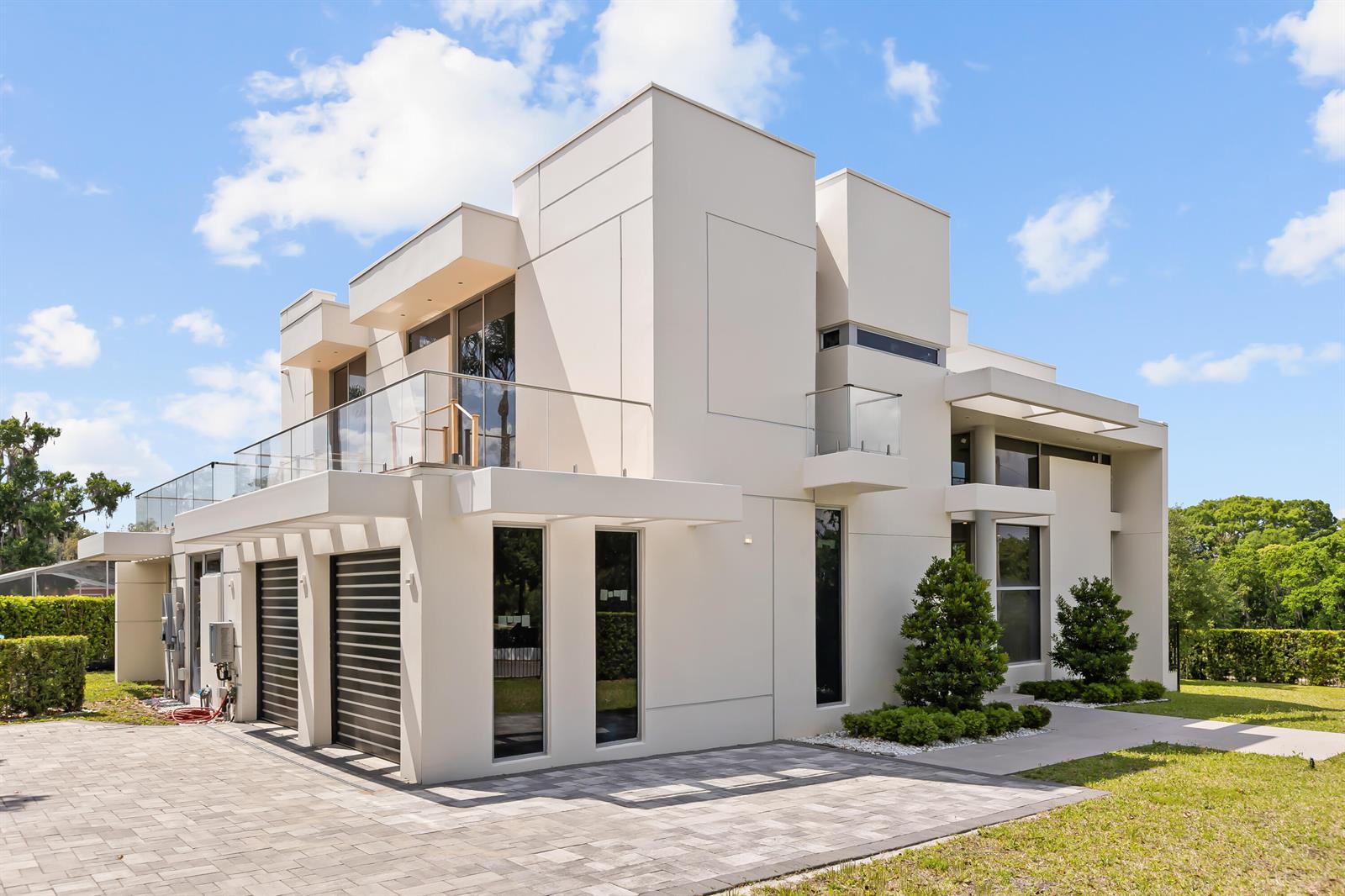 A modern two-story house with a flat roof, glass balconies, and a paved driveway — 2661 Via Tuscany, Winter Park FL 32789, WINTER PARK, FL