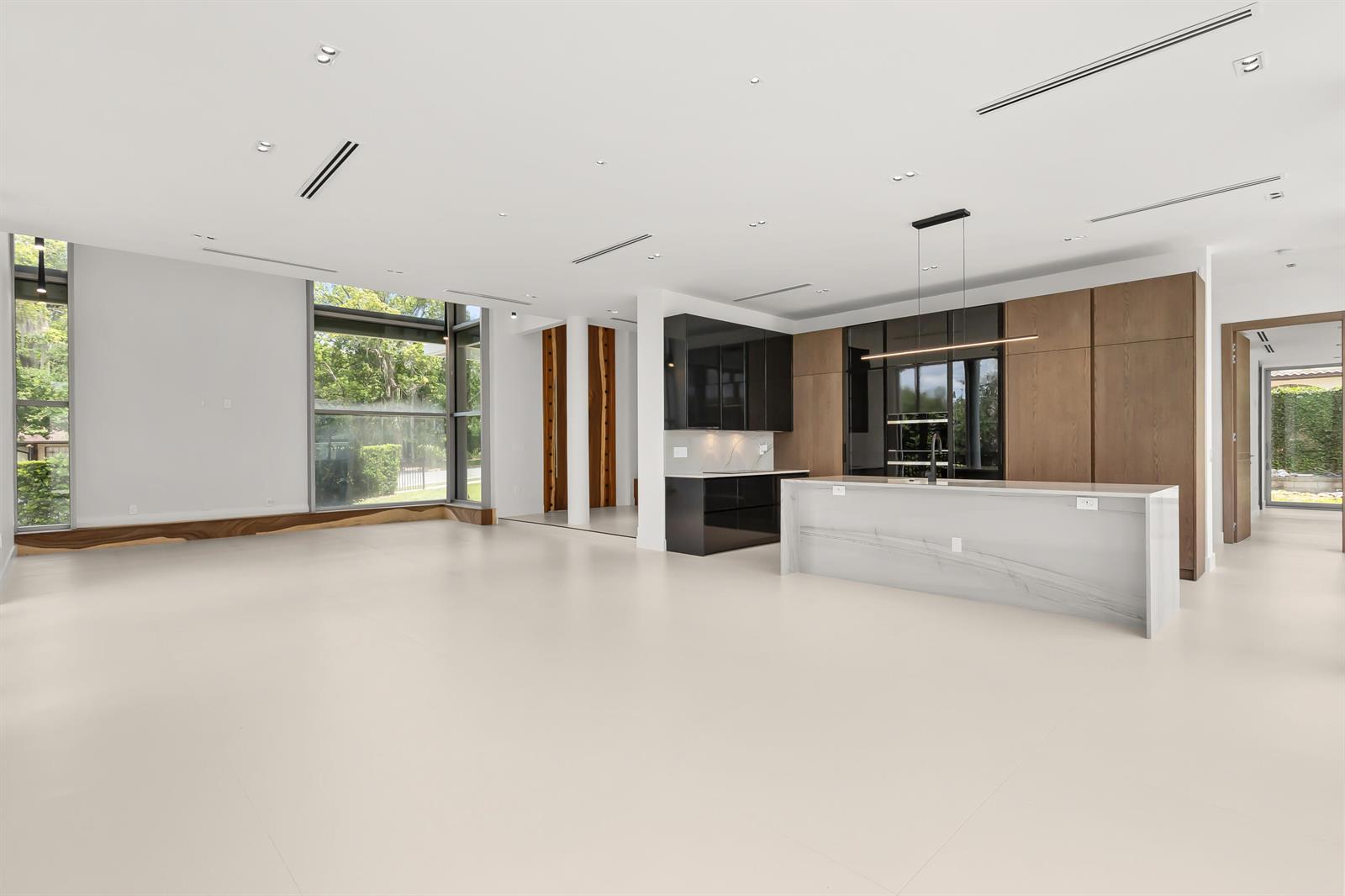 A modern open-concept kitchen and living area features light floors, wood cabinetry, and large windows — 2661 Via Tuscany, Winter Park FL 32789, WINTER PARK, FL