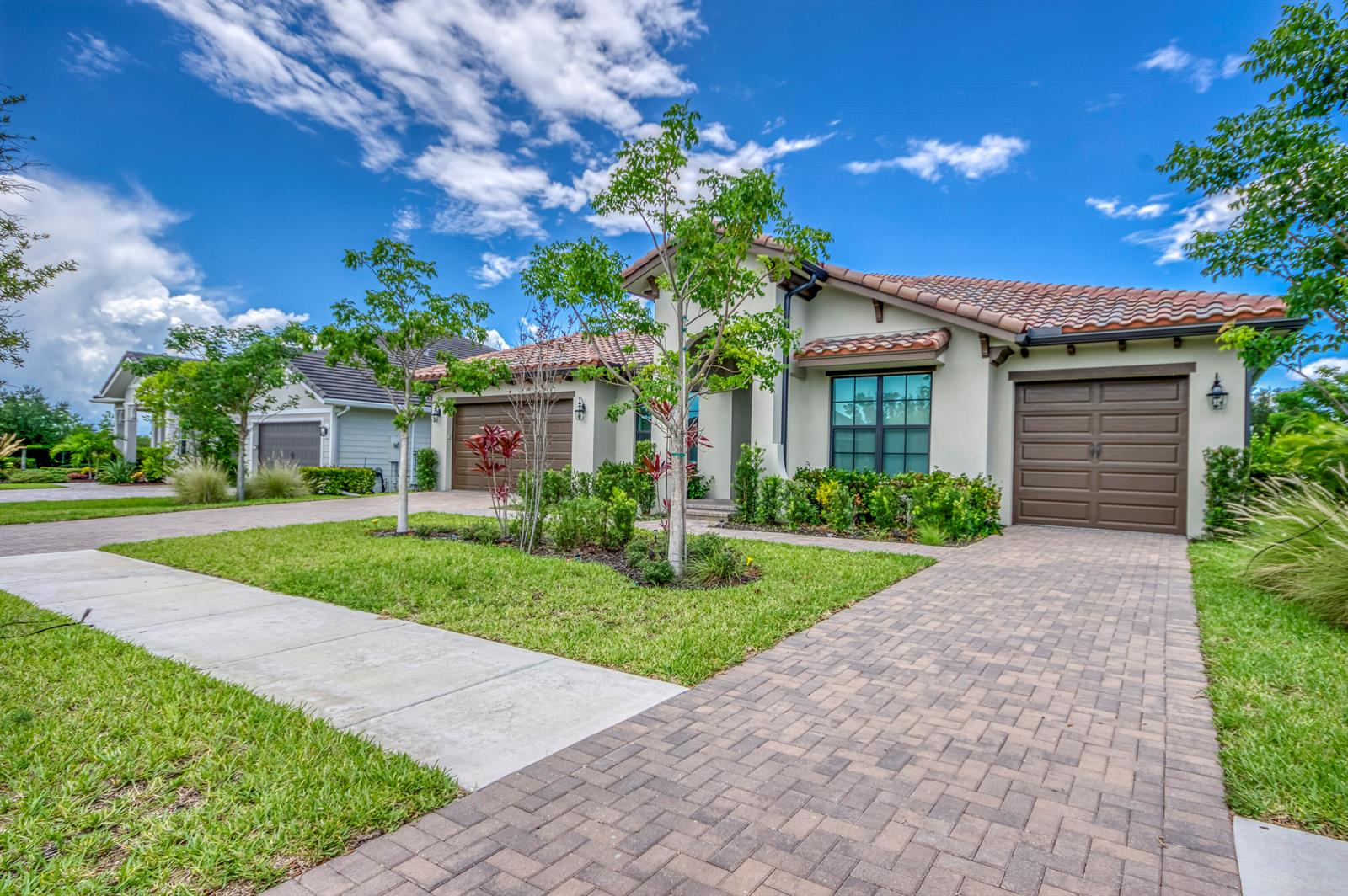A single-story house with a tile roof, brown garage doors, and a paved driveway — 19077 Fly Rod Run, FL 33470, FL