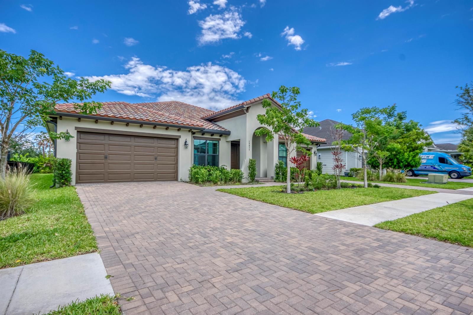 A single-story house with a tiled roof, brown garage door, and a paved driveway — 19077 Fly Rod Run, FL 33470, FL