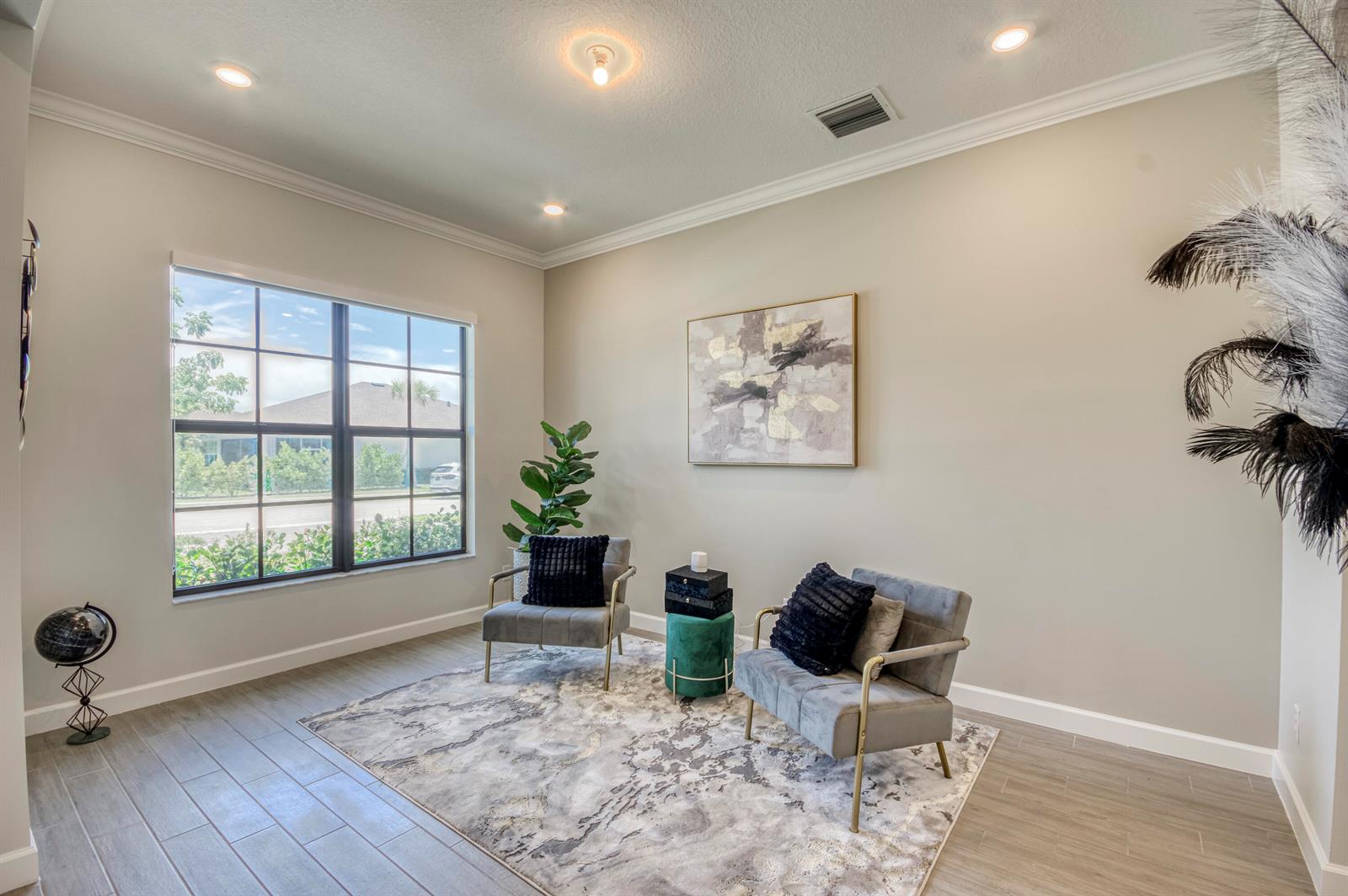 A sitting room features two gray armchairs, a patterned area rug, and a large window — 19077 Fly Rod Run, FL 33470, FL